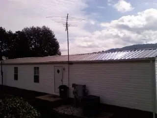 New metal roof on a single wide mobile home with a TV antenna in Oak View